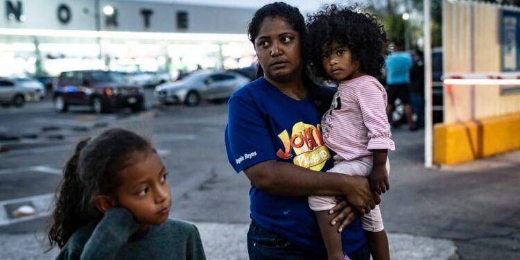 Yirbelin Muñoz espera con su hija Samantha León y su sobrina Aylin Muñoz en el estacionamiento de la Central de Cutobuses del Norte en Ciudad de México. Estados Unidos adoptó una política de ayuda humanitaria inspirada en la normativa para la inmigración ucrania. NAYELI CRUZ