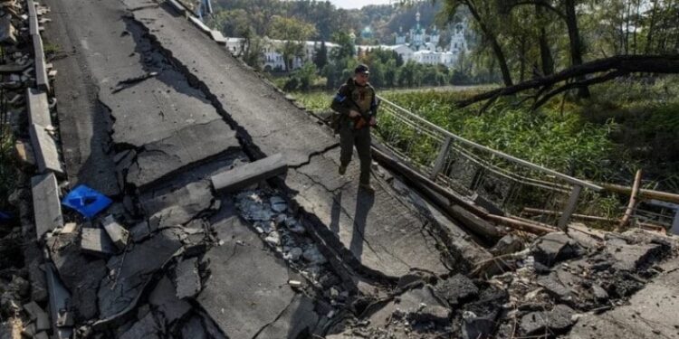 Un miembro del servicio de la Guardia Nacional de Ucrania camina por un puente sobre el río Siverskyi Donets destruido durante el ataque de Rusia a Ucrania, en la ciudad de Sviatohirsk, región de Donetsk, Ucrania 1 de octubre de 2022. REUTERS/Vladyslav Musiienko