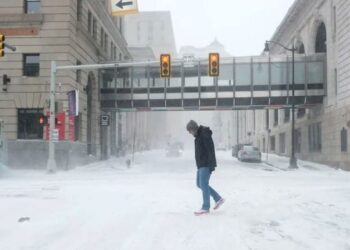 Residentes de Detroit desafían las gélidas temperaturas y las fuertes ráfagas de viento en el centro de Detroit el 23 de diciembre de 2022 en Detroit, Estados Unidos (AFP)