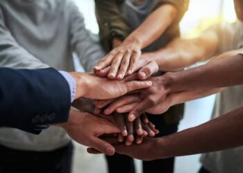 Cropped shot of a group of businesspeople joining their hands in solidarity