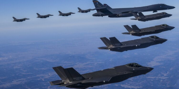 In this photo provided by South Korea Defense Ministry, a U.S. Air Force B-1B bomber, center, flies in formation with South Korea's Air Force F-35A fighter jets, bottom, and U.S. Air Force F-16 fighter jets, top, over the South Korea Peninsula during a joint air drill in South Korea, Sunday, Feb. 19, 2023. (South Korea Defense Ministry via AP)