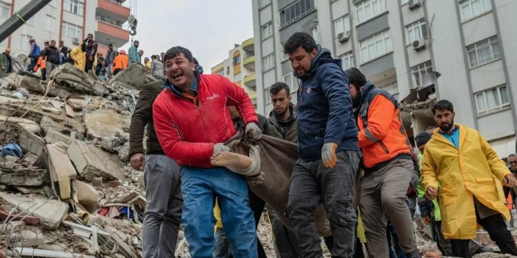 Los rescatistas llevan un cuerpo encontrado entre los escombros en Adana.