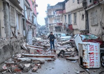 A man runs along a street strewn with debris, in Hatay,  the day after a 7.8-magnitude earthquake struck the country's southeast on February 7, 2023. - Rescuers in Turkey and Syria braved frigid weather, aftershocks and collapsing buildings, as they dug for survivors buried by an earthquake that killed more than 5,000 people. Up to 23 million people could be affected by the massive earthquake that has killed thousands in Turkey and Syria, the WHO warned on Tuesday, promising long-term assistance. (Photo by BULENT KILIC / AFP)