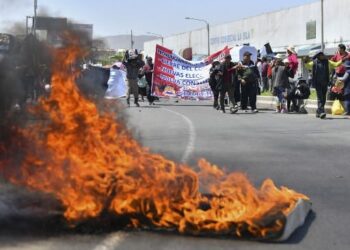 Demonstrators hold a blockade in the Pan-American highway at La Joya to demand the resignation of Peruvian President Dina Boluarte in Arequipa, Peru on January 12, 2023. - Leftist groups announced mobilizations in Lima this Thursday to demand the resignation of President Dina Boluarte and early elections, as part of the protests that left at least 42 dead in just over a month, with major outbreaks in Andean areas such as Cusco, a mecca of tourism whose airport closed for security. (Photo by Diego Ramos / AFP)