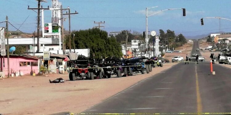 Members of the army and police secure the perimeter at the site of a long-gun attack on a group of amateur rally drivers in Ensenada, Mexico, on May 20, 2023. At least 10 people were killed and nine wounded on Saturday when gunmen attacked a group of amateur rally drivers in the northern Mexican town of Ensenada, near the US border, authorities said. (Photo by Joatam DE BASADE / AFP)