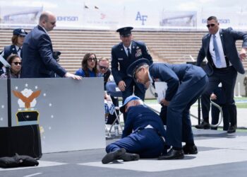 US President Joe Biden is helped up after falling during the graduation ceremony at the United States Air Force Academy, just north of Colorado Springs in El Paso County, Colorado, on June 1, 2023. (Photo by Brendan Smialowski / AFP)
