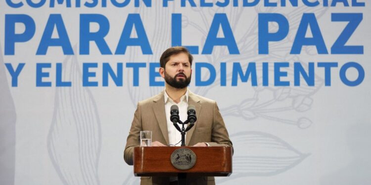 This handout picture released by the Chilean Presidency shows Chile's President Gabriel Boric speaking during the launch of the Presidential Commission for Peace and Understanding in Santiago on June 21, 2023. Boric launched on Wednesday a Commission for Peace and Understanding that will seek to resolve the conflict with Mapuche communities in the south of the country, an area hit by violence and arson attacks. "I have the hope, the conviction that the commission, through broad social dialogue and agreements, lays the foundations for a lasting solution to the conflict that has existed for a long time between the Chilean State and the Mapuche people", said the leftist. (Photo by Fernando RAMIREZ / Chilean Presidency / AFP) / RESTRICTED TO EDITORIAL USE - MANDATORY CREDIT "AFP PHOTO / CHILEAN PRESIDENCY" - NO MARKETING NO ADVERTISING CAMPAIGNS - DISTRIBUTED AS A SERVICE TO CLIENTS