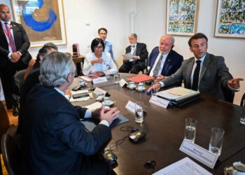 France's President Emmanuel Macron (R) gestures as he speaks with Vice President of Venezuela Delcy Rodriguez (2L), Brazil's President Luiz Inacio Lula da Silva (C), Colombia's President Gustavo Petro (from the back L) and Argentina's President Alberto Fernandez (from the back R) during a meeting on the sidelines of a summit of European Union-Community of Latin American and Caribbean States Summit (EU-CELAC) at The European Council Building in Brussels on July 17, 2023. (Photo by Emmanuel DUNAND / POOL / AFP)