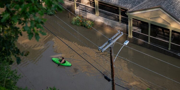 MONTPELIER, VERMONT - JULY 11: In an aerial view, a kayaker paddles through the flooded waters of Elm Street on July 11, 2023 in Montpelier, Vermont. Up to eight inches of rain fell over 48 hours and residents were warned that Wrightsville Dam could reach capacity, forcing it to release more water that could impact the downtown area.   Kylie Cooper/Getty Images/AFP (Photo by Kylie Cooper / GETTY IMAGES NORTH AMERICA / Getty Images via AFP)