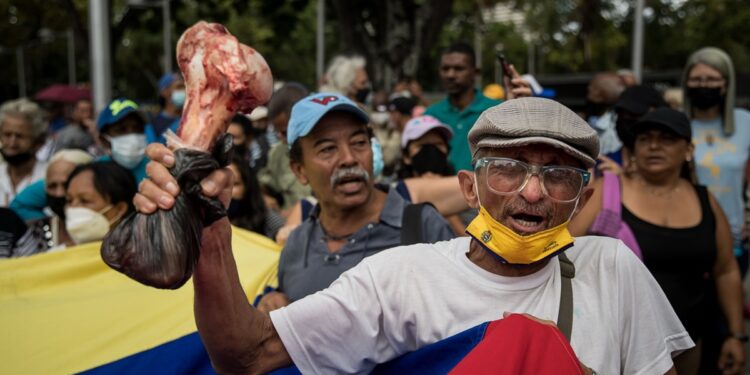 AME6922. CARACAS (VENEZUELA), 02/08/2022.- Grupos de personas participan en una manifestación para exigir pagos pendientes así como que se respeten sus derechos contractuales en una movilización que denominaron "la marcha de las ollas vacías" hoy, en Caracas (Venezuela). Un millar de docentes, empleados públicos y jubilados venezolanos protestaron este martes en el centro de Caracas para exigir pagos pendientes así como que se respeten sus derechos contractuales en una movilización que denominaron "la marcha de las ollas vacías". EFE/ Miguel Gutiérrez
