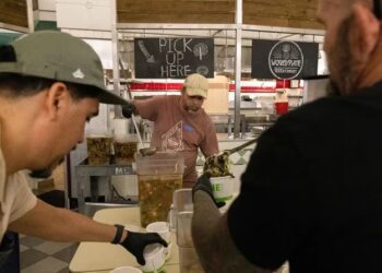 Los voluntarios preparan comidas gratis para donar a las familias del oeste de Maui afectadas por los incendios forestales, en el University of Hawaii Maui College en Kahului, en el centro de Maui, Hawaii, el 13 de agosto de 2023. (Foto de Yuki IWAMURA / AFP)