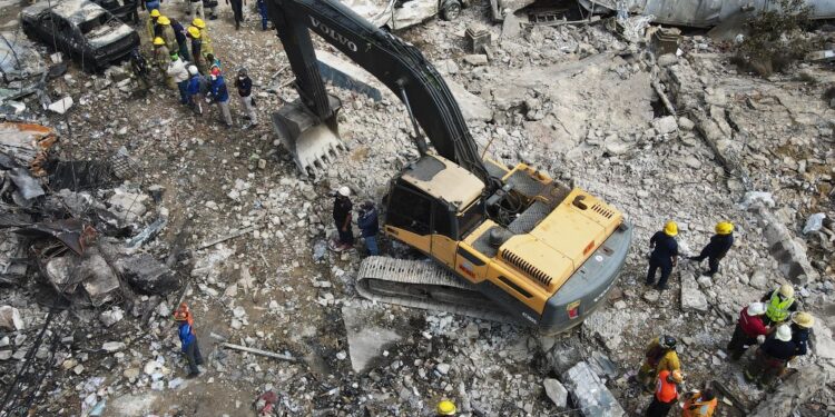 Aerial view of municipal workers working on the zone affected by an explosion in a commercial establishment in San Cristobal, Dominican Republic on August 15, 2023. At least 10 people were killed, 37 injured, and 11 were missing in a powerful explosion in a commercial area in the capital of the Dominican Republic, said President Luis Abinader on Tuesday as he gave an updated balance sheet. (Photo by STRINGER / AFP)