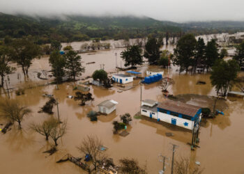 AME3628. TALCA (CHILE), 22/08/2023.- Fotografía aérea tomada hoy que muestra las inundaciones causadas tras el desborde del río Claro en la ciudad de Talca (Chile). El gobierno chileno declaró este martes emergencia agrícola en las regiones de O'Higgins, Maule, Ñuble y Biobío, territorios del centro sur que comprenden el área más afectada por el histórico sistema frontal, fenómeno que desde el pasado sábado han dejado tres personas fallecidas, casi 4.300 damnificadas, más de 850 albergadas y más de 34.000 aisladas. EFE/ Rafael Arancibia