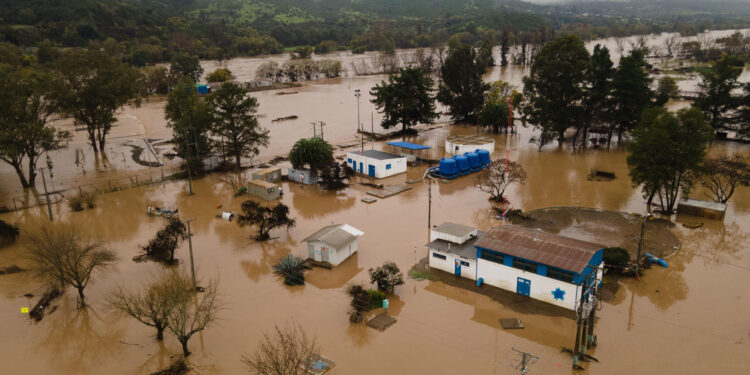 AME3628. TALCA (CHILE), 22/08/2023.- Fotografía aérea tomada hoy que muestra las inundaciones causadas tras el desborde del río Claro en la ciudad de Talca (Chile). El gobierno chileno declaró este martes emergencia agrícola en las regiones de O'Higgins, Maule, Ñuble y Biobío, territorios del centro sur que comprenden el área más afectada por el histórico sistema frontal, fenómeno que desde el pasado sábado han dejado tres personas fallecidas, casi 4.300 damnificadas, más de 850 albergadas y más de 34.000 aisladas. EFE/ Rafael Arancibia