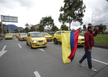 Taxi drivers block the streets during a demonstration against the government's decision to increase the price of gasoline in Bogota, on August 9, 2023. (Photo by Juan Pablo Pino / AFP)