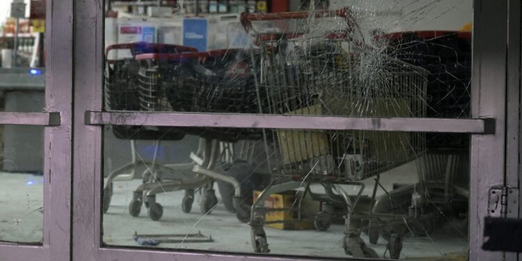 Picture of the broken glass of door at a "Dia" supermarket taken after it was looted, in Jose C. Paz on the outskirts of Buenos Aires on August 22, 2023. Almost thirty people were arrested in Argentina after looting of commercial premises over the weekend in the provinces of Cordoba and Mendoza, events which the government described as "criminal acts" aimed at creating confusion in the midst of the campaign for the October presidential elections. An attempt to loot a store in Buenos Aires was reported on Monday night, which was prevented by neighbours. (Photo by Juan MABROMATA / AFP)