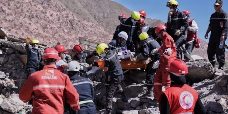 Rescatistas marroquíes trabajan en equipo para rescatar a una víctima del terremoto (Fernando Sánchez/Europa Press)