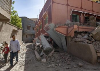 Marrakesh (Morocco), 09/09/2023.- A person with a child walk next to a damaged building following an earthquake in Marrakesh, Morocco, 09 September 2023. A powerful earthquake that hit central Morocco late 08 September, killed at least 820 people and injured 672 others, according to a provisional report from the country's Interior Ministry. The earthquake, measuring magnitude 6.8 according to the USGS, damaged buildings from villages and towns in the Atlas Mountains to Marrakesh. (Terremoto/sismo, Marruecos) EFE/EPA/JALAL MORCHIDI