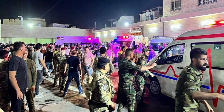 Soldiers and emergency responders gather around ambulances carrying wounded people after a fire broke out during a wedding at an event hall, outside the Hamdaniyah general hospital in Al-Hamdaniyah, Iraq on September 27, 2023. At least 100 people were killed and more than 150 injured when a fire broke out during a wedding at an event hall in the northern Iraqi town of Al-Hamdaniyah, according to state media and health officials, on September 27, 2023. (Photo by Zaid AL-OBEIDI / AFP)