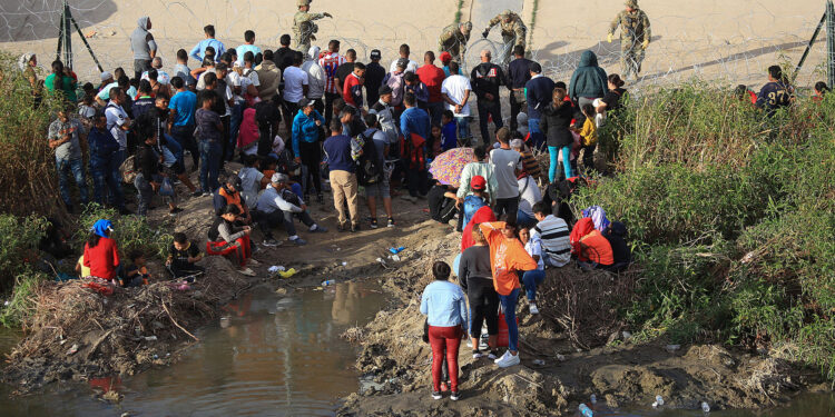 MEX5196. CIUDAD JUÁREZ (MÉXICO), 13/09/2023.- Un grupo de migrantes permanecen a un costado de la frontera con Estados Unidos, en Ciudad Juárez, Chihuahua (México). La desesperación de los migrantes por pasar a Estados Unidos a través de la mexicana Ciudad Juárez ha aumentado lo que ha provocado que muchos pongan en riesgo su vida al intentan cruzar a través de las peligrosas barricadas construidas con alambrada de navajas. EFE/Luis Torres