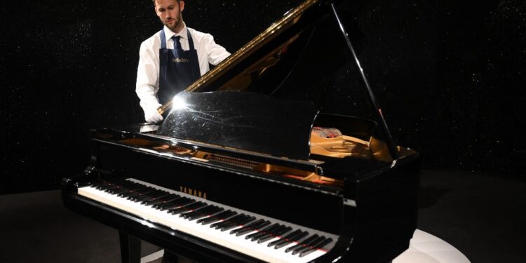 (FILES) Freddie Mercury's Yamaha G-2 baby grand piano, is pictured during a press preview ahead of the "Freddie Mercury: A World of His Own" auctions, at Sotheby's auctioneers in London on August 3, 2023. Thousands of items belonging to the charismatic Queen frontman Freddie Mercury, from manuscripts of his band's biggest hits to furniture, paintings and knick-knacks, go under the hammer in London. (Photo by Daniel LEAL / AFP)