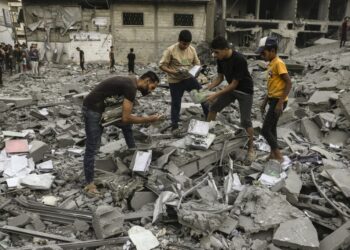 People salvage belongings from the rubble of a building levelled in an Israeli strike on Rafah in the southern Gaza Strip on October 15, 2023. Israel embarked on a withering air campaign against Hamas militants in Gaza after they carried out a brutal attack on Israel on October 7 that left more than 1,400 people killed in Israel. (Photo by Mohammed ABED / AFP)