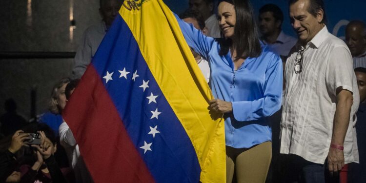 CARACAS (VENEZUELA) 23/10/2023 - La exdiputada Maria Corina Machado (c) sonríe mientras celebra junto a aliados y seguidores en las primeras horas de este lunes los resultados ofrecidos por la comisión de elecciones primarias, en Caracas (Venezuela). La exdiputada María Corina Machado es la gran triunfadora de las primarias opositoras de este domingo en Venezuela, con el 93,13 % de los votos, con un 26,06 % de las actas escrutadas, de unas votaciones en las que los venezolanos eligieron a quien debe enfrentarse al chavismo en las presidenciales de 2024. EFE/ Miguel Gutiérrez