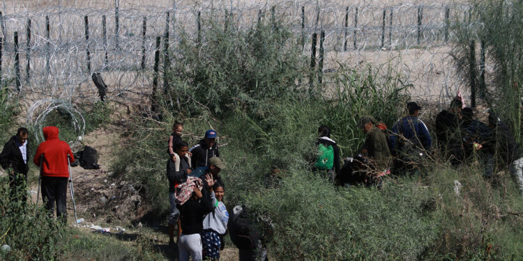 MEX7640. CIUDAD JUÁREZ (MEXICO), 08/10/2023.- Un grupo de migrantes permanecen a un costado de la frontera con Estados Unidos, el 7 de octubre de 2023 en Ciudad Juárez, Chihuahua (México). Los miles de venezolanos varados en la frontera norte de México, el mayor número de migrantes, reaccionan con temor ante el anuncio del Gobierno de Estados Unidos por retomar las deportaciones directas a Venezuela, alejándolos del sueño americano, en medio de la nueva ola migratoria sin precedentes. EFE/Luis Torres