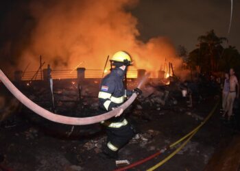 A firefighter works during a large fire in the Ricardo Brugada neighborhood, known as "La Chacarita", in the vicinity of the Cabildo in Asuncion on October 6, 2023. (Photo by Daniel DUARTE / AFP)