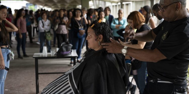 Volunteers cut donors' hair during a human and animal hair donation campaign promoted by the environmental movement "Proyecto Sirena" at the Central University of Venezuela (UCV) in Caracas on October 6, 2023. Hundreds of Venezuelans come to get their hair cut, some with their pets, to support the initiative that aims to use human and animal hair to contribute to the cleanup of Lake Maracaibo, in Zulia State, highly contaminated by constant oil spills. (Photo by Yuri CORTEZ / AFP)