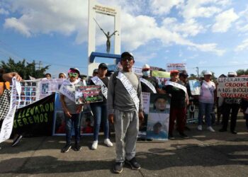 AME7699. SAN SALVADOR (EL SALVADOR), 18/11/2023.- Personas protestan hoy, en una calle de San Salvador (El Salvador). Más de 300 personas protestaron este sábado por las detenciones arbitrarias y muertes de "inocentes" en el contexto del régimen de excepción, y acusaron al Gobierno del presidente Nayib Bukele de "maquillar" los atropellos con la acogida del concurso de Miss Universo, que celebra hoy su gala final en el país centroamericano. EFE/ Miguel Lemus