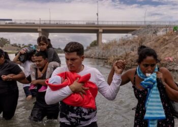 ARCHIVO - Yusniel, un migrante de Cuba, sostiene a su hijo de 10 días, Yireht, y a su esposa, Yanara, mientras buscan un punto de entrada más allá de una cerca de alambre a lo largo de la orilla del río Grande en Eagle Pass, Texas, EEUU, el 6 de octubre de 2023.