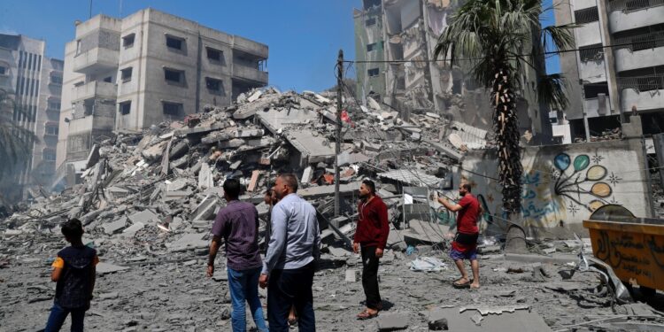 People inspect the rubble of a destroyed residential building that was hit by an Israeli airstrike, in Gaza City, Sunday, May 16, 2021. (AP Photo/Adel Hana)