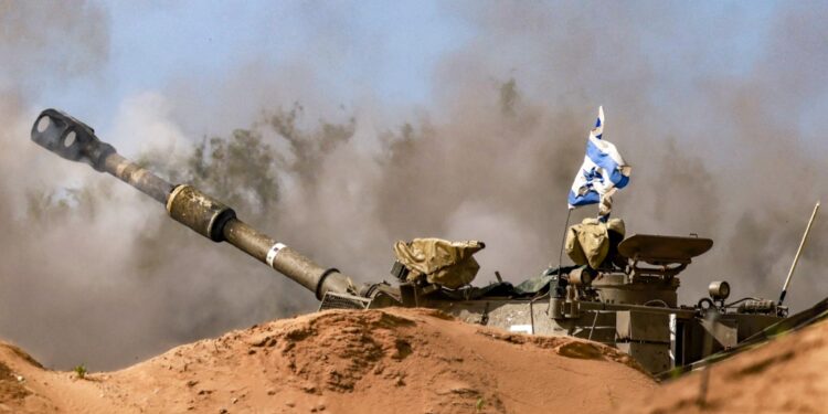 An Israeli army self-propelled artillery howitzer fires rounds from a position near the border with the Gaza Strip in southern Israel on December 24, 2023. (Photo by Menahem KAHANA / AFP)