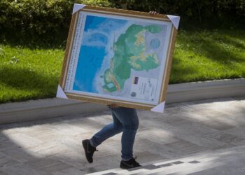 -FOTODELDÍA- AME2481. CARACAS (VENEZUELA), 06/12/2023.- Un hombre carga hoy un cuadro del mapa de Venezuela con la adhesión del Esequibo, en uno de los jardines del Palacio Federal Legislativo en Caracas (Venezuela). La Asamblea Nacional (AN, Parlamento) de Venezuela, controlada por el chavismo, prevé aprobar dentro de una semana la ley de anexión del territorio en disputa con Guyana, en cumplimiento del referendo unilateral celebrado el domingo relacionado con este conflicto, aseguró el presidente de la Cámara, Jorge Rodríguez. EFE/ MIGUEL GUTIERREZ