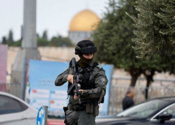 A member of Israeli border police stands guard as Palestinians attend Friday prayers outside the Old City of Jerusalem, October 20, 2023. REUTERS/Ammar Awad