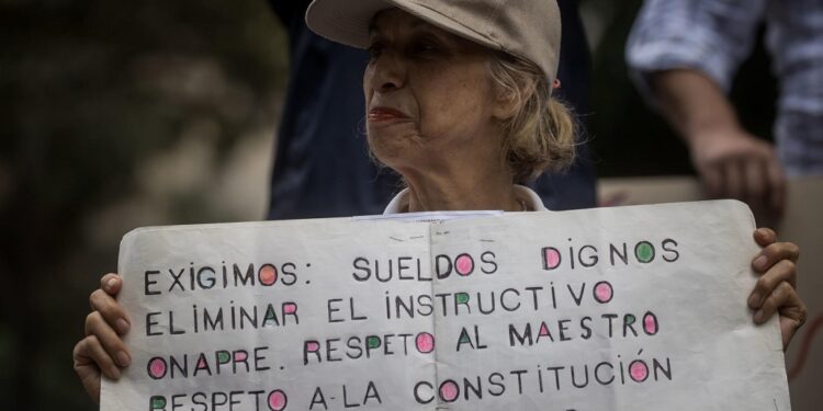 AME632. CARACAS (VENEZUELA), 18/01/2024.- Una persona muestra un cartel de protesta durante una manifestación de trabajadores que exigen mejores salarios y condiciones laborales, el 15 de enero de 2024, en Caracas (Venezuela). Los trabajadores públicos de Venezuela inician otro año de protestas contra los "salarios de hambre", una lucha que planean intensificar hasta que el clamor por un ingreso que satisfaga sus necesidades reciba, finalmente, una respuesta de las autoridades acorde a sus demandas, dijeron sindicalistas a EFE. Cientos de trabajadores llevaron a cabo el lunes la segunda jornada de manifestaciones de 2024, que finalizó con el anuncio del presidente Nicolás Maduro de un aumento de 30 a 60 dólares de una bonificación mensual sin incidencia en el cálculo de beneficios como las prestaciones, mientras que el salario mínimo se mantiene, desde marzo de 2022, en 130 bolívares, hoy 3,6 dólares al mes. EFE/ Miguel Gutiérrez