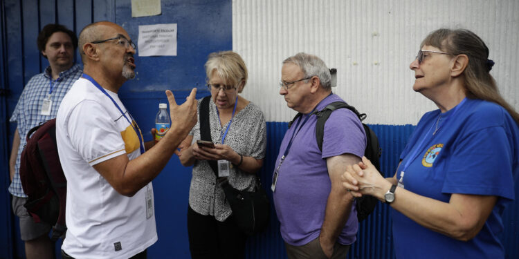 ES6001.SAN SALVADOR (EL SALVADOR) 3/02/2024.- Observadores electorales internacionales esperan a las afueras de un centro de votación, hoy en San Salvador (El Salvador). El Salvador cumple este sábado cinco años de las elecciones presidenciales de 2019 que generaron un terremoto político en el país centroamericano y llevaron al poder a Nayib Bukele, quien el domingo se presentará a la reelección a pesar de la prohibición constitucional. EFE/Rodrigo Sura