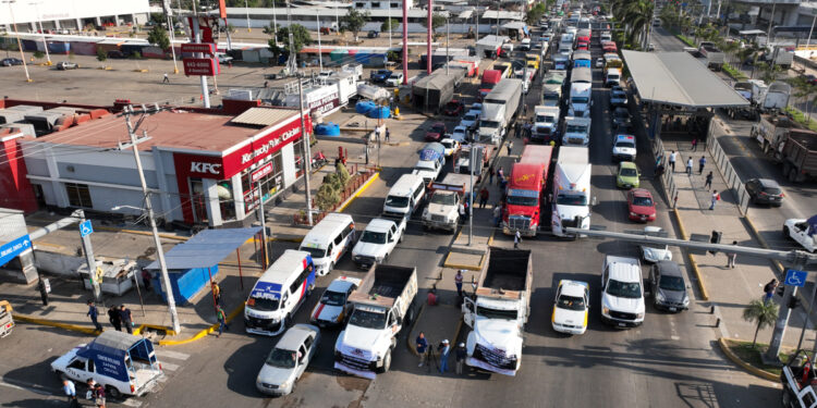 MEX8529. ACAPULCO (MÉXICO), 15/02/2024.- Transportistas bloquean una carretera este jueves en el balneario de Acapulco (México). La Alianza Mexicana de Organizaciones de Transportistas (Amotac) paralizó este jueves las carreteras de México con un paro nacional para denunciar un alza de la violencia del crimen organizado, con pérdidas estimadas en 7.000 millones de pesos (más de 400 millones de dólares) en 2023. EFE/David Guzmán