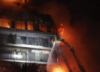 VALENCIA, 22/02/2024.- Vista del incendio declarado sobre las cinco y media de esta tarde en un quinto piso de un edificio de viviendas de València que ha afectado totalmente al inmueble y se ha propagado a otro anexo, y los bomberos intentan aún rescatar a vecinos desde los balcones. EFE/Manuel Bruque