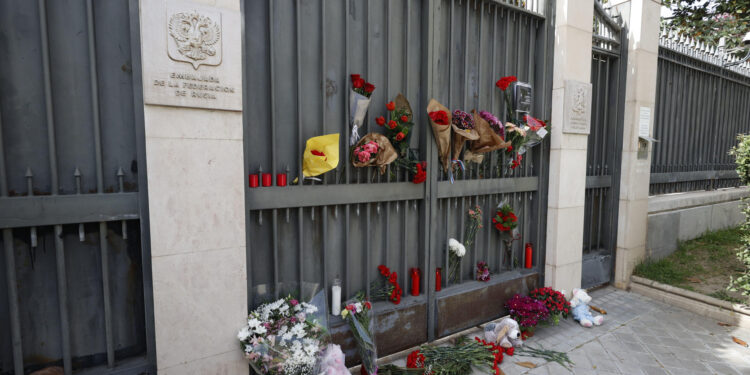 MADRID, 23/03/2024.- Flores y velas han sido depositadas por ciudadanos anónimos en la entrada de la embajada de Rusia en Madrid este sábado. Las autoridades rusas elevaron este martes a 133 el número de los muertos en el ataque terrorista del viernes contra a sala de conciertos Crocus City Hall, a las afueras de Moscú. El grupo terrorista Estado Islámico (EI) difundió este sábado una imagen de los cuatro presuntos responsables del atentado . EFE/ Javier Lizón