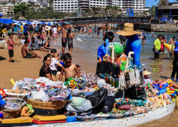 MEX3233. ACAPULCO (MÉXICO), 30/03/2024.- Fotografía de bañistas en una playa, el 29 de marzo de 2024, en el balneario de Acapulco (México). Aunque aún permanecen restos de la destrucción causada por el histórico huracán Otis, el turismo ha revivido esta Semana Santa en el puerto mexicano de Acapulco, estado de Guerrero, sur de México, con playas llenas y una ocupación cercana al 90 % en 177 hoteles. EFE/ David Guzmán