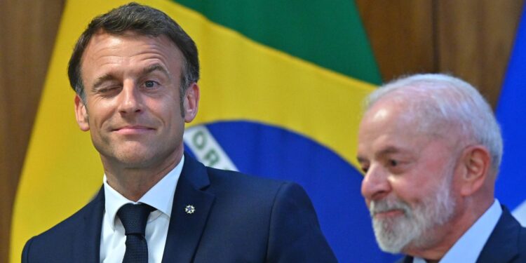 AME3322. BRASILIA (BRASIL), 28/03/2024.- El presidente de Francia, Emmanuel Macron (i), reacciona junto del presidente de Brasil, Luiz Inácio Lula da Silva, durante una ceremonia este jueves, en el Palacio del Planalto, en Brasilia (Brasil). Lula y su homólogo francés, Emmanuel Macron, discuten este jueves asuntos de la realidad regional y global, durante la última jornada de la visita de tres días del líder galo a Brasil. EFE/Andre Borges