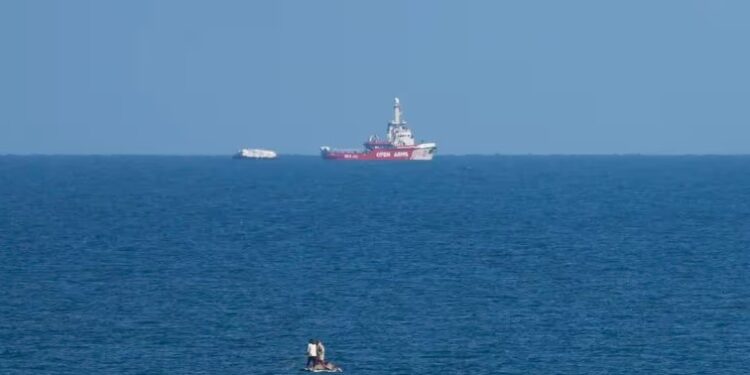 Un barco de la ONG Open Arms se acerca a la costa de Gaza remolcando una barcaza con 200 toneladas de ayuda humanitaria (AP Foto/Abdel Kareem Hana)