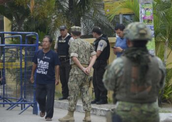 Security forces guard a polling station during a referendum on tougher measures against organized crime in Olon, Santa Elena province, Ecuador, on April 21, 2024. Ecuadorans began voting Sunday in a referendum on proposed tougher measures to fight gang-related crime. The once-peaceful South American country has been grappling with a shocking rise in violence that has seen two mayors killed this week. (Photo by Gerardo MENOSCAL / AFP)