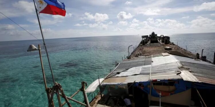 Una bandera filipina ondea desde el Sierra Madre, un destartalado buque de la Armada filipina encallado desde 1999 y convertido en destacamento militar filipino en el disputado atolón Second Thomas. (REUTERS/Erik De Castro/archivo)