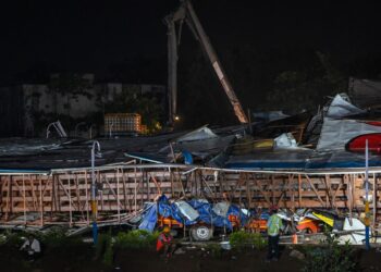 A rescue worker inspects the site where an advertisement billboard collapsed at a petrol station following a dust storm in Mumbai on May 13, 2024. (Photo by Punit PARANJPE / AFP)