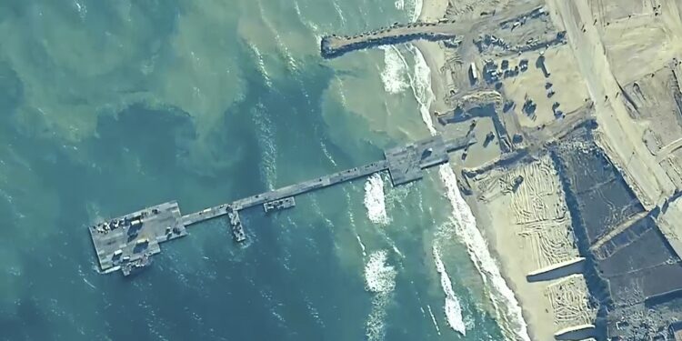 Esta imagen, distribuida por el Comando Central de Estados Unidos, muestra a soldados de su 7ma Brigada de Transporte, a marinos del Batallón Anfibio de Construcción 1 y a efectivos de las Fuerzas de Defensa de Israel, instalando el muelle Trident en la costa de la Franja de Gaza, el 16 de mayo de 2024. (Comando Central de Estados Unidos vía AP)