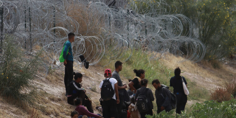 MEX227. CIUDAD JUÁREZ (MÉXICO), 05/06/2024.- Migrantes permanecen cerca del muro que separa la frontera estadounidense, el 4 de junio de 2024, en Ciudad Juárez, Chihuahua (México). Tras el anuncio de que Estados Unidos limitará el número de asilos otorgados a migrantes que ingresen irregularmente, y temperaturas cercanas a los 40 grados, los centenares migrantes que esperaban para cruzar en la frontera entre Juárez (Chihuahua) y El Paso (Texas) se retiraron para evitar problemas. EFE/Luis Torres