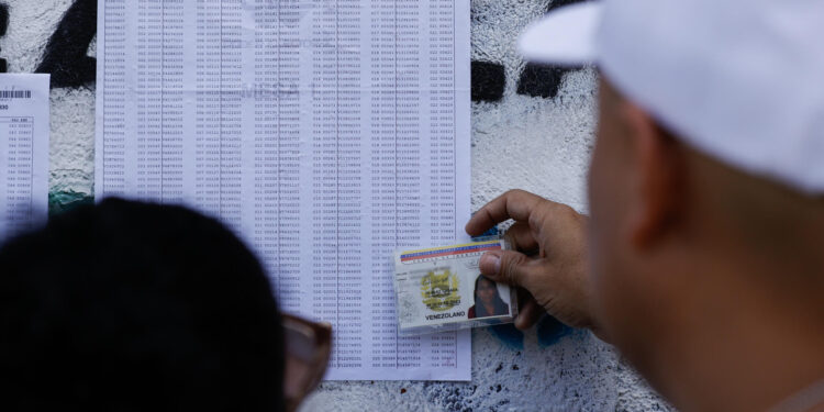 AME5617. CARACAS (VENEZUELA), 28/07/2024.- Un ciudadano venezolano busca su mesa de votación durante la jornada de elecciones presidenciales de Venezuela este domingo, en Caracas (Venezuela). El CNE informó este domingo que, sobre las 08.00 hora local (12.00 GMT), el 95 % de los 15.797 centros de votación ya estaban abiertos -dos horas más tarde la hora oficial fijada para la apertura- y computando los votos de personas que acudieron desde muy temprano a las urnas. EFE/ Henry Chirinos